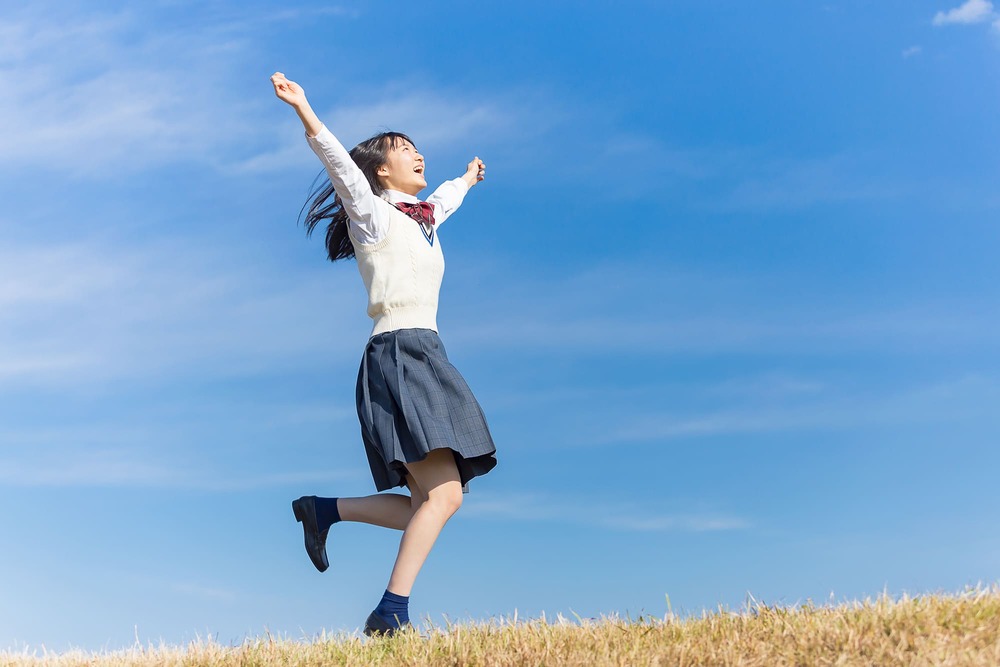 手を広げ喜ぶ女子高生