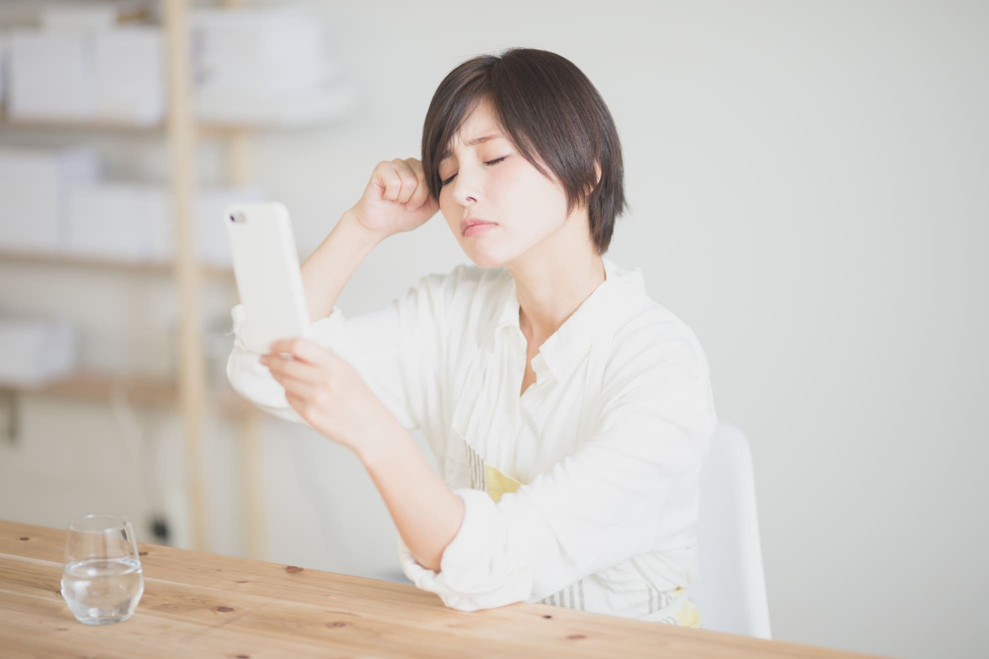 スマホを見て悩む女性