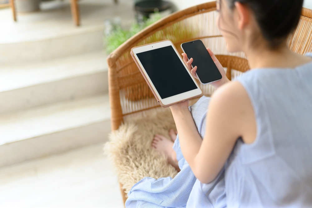 タブレットとスマホを両方持つ女性