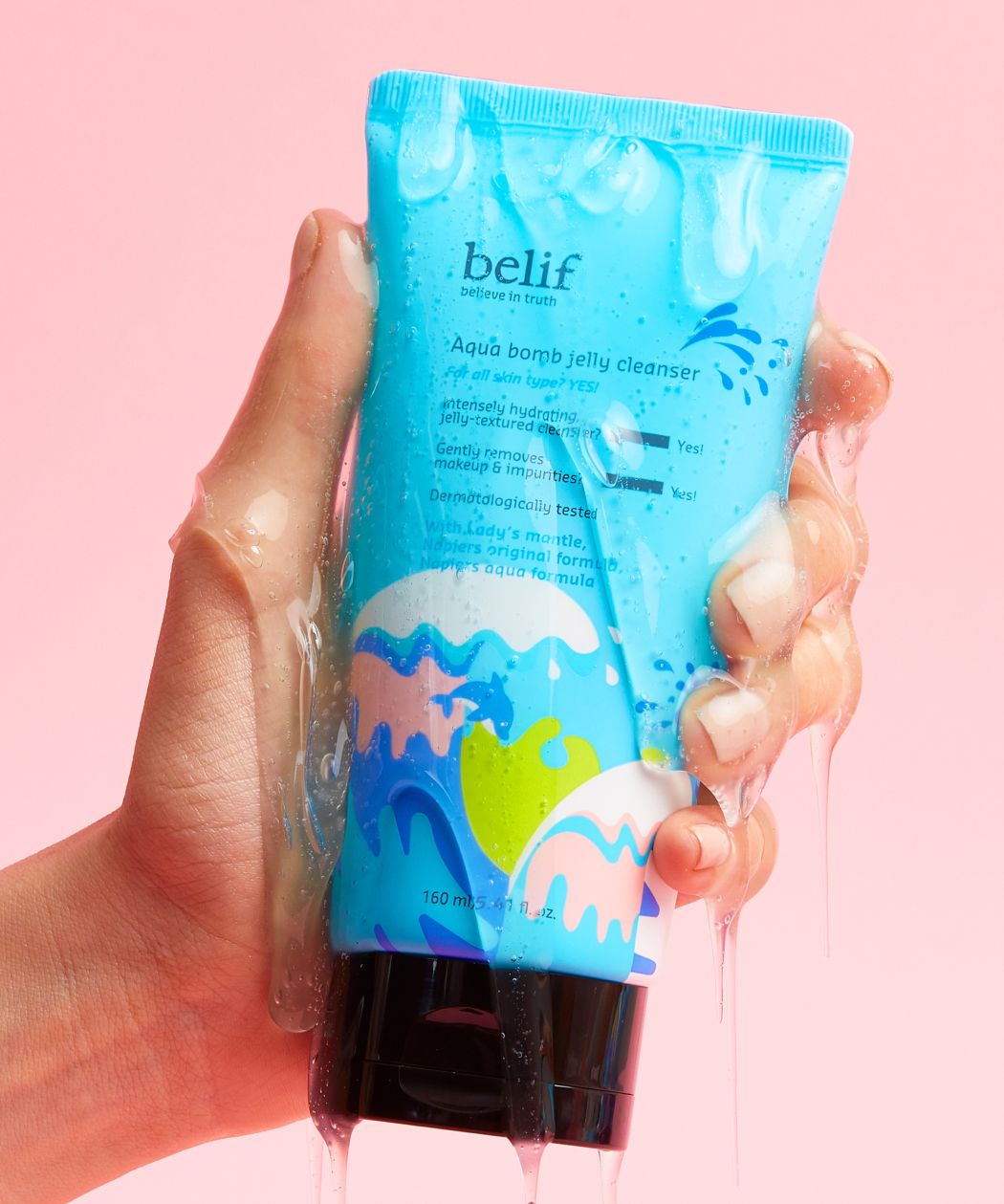 A hand holding a blue tube belif Aqua Bomb Jelly Cleanser