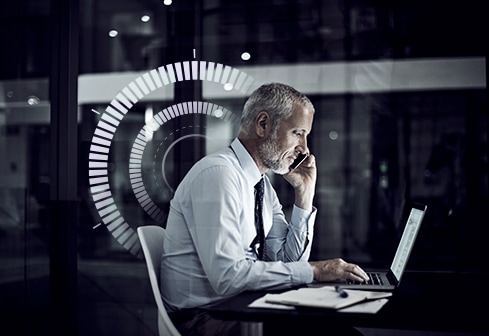 man on phone while at computer 