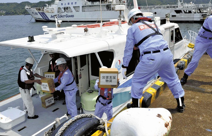 下田港に到着した港湾業務艇から災害支援物資に見立てた段ボール箱を運び出す参加者（６日、下田市で）