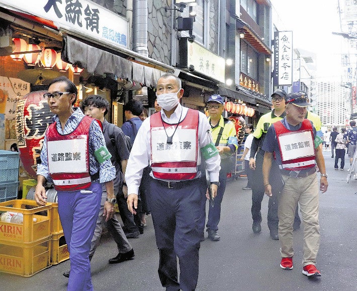 新橋駅周辺の繁華街を巡回する指導員ら（７月２４日、東京都港区で）