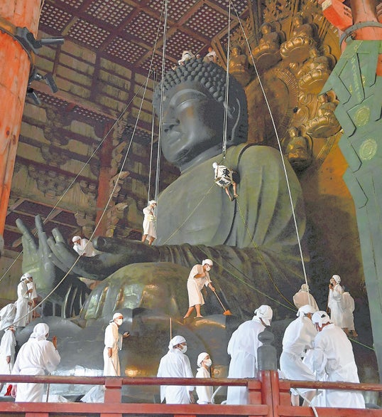 大仏に積もったほこりを払う僧侶や信徒ら（奈良市で）