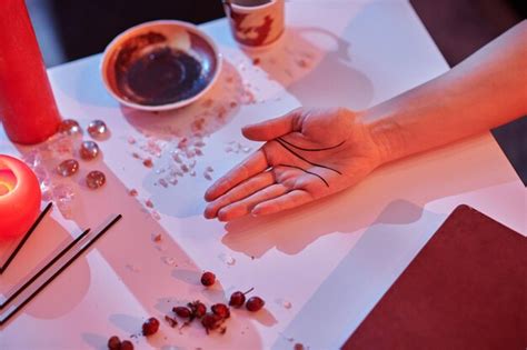 Premium Photo | Cropped photo of a palmist hand lying on the divination ...