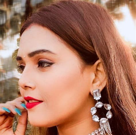 a woman with long brown hair wearing earrings