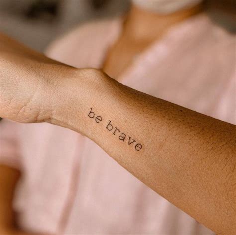 "Be brave" lettering tattoo on the wrist.