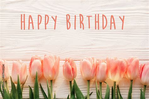 happy birthday text sign on pink tulips on white rustic wooden ...