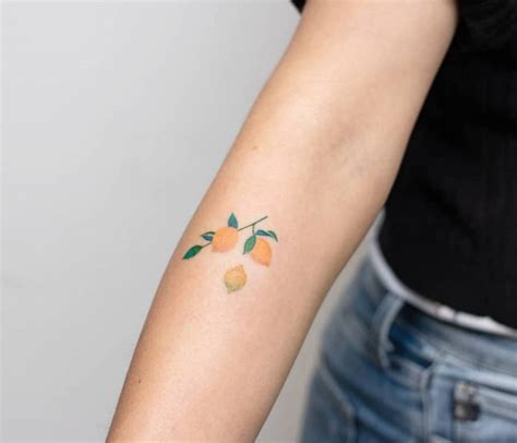 Hand poked lemon branch tattoo on the forearm.