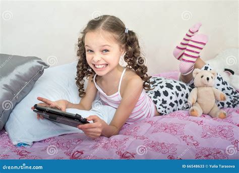 Happy Little Girl Lying on Bed with Tablet Computer Stock Image - Image ...