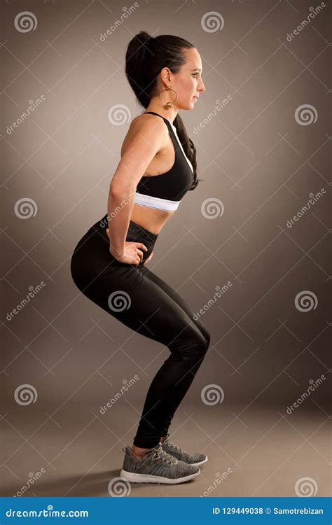 Beautiful Young Sporty Woman in Squat Pose Over Grey Background Stock ...