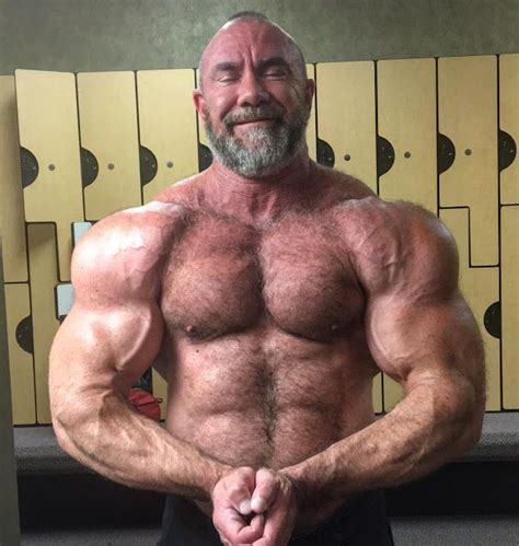 a man posing for the camera in front of lockers with his hands on his hips