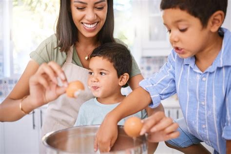 Premium Photo | Mother boy and children with egg for boiling cooking ...