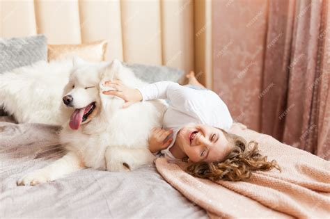 Premium Photo | Home portrait of cute child hugging with dog on the sofa