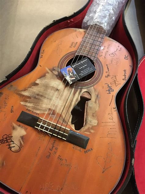 an acoustic guitar with writing on it and a case for the ukulele is shown