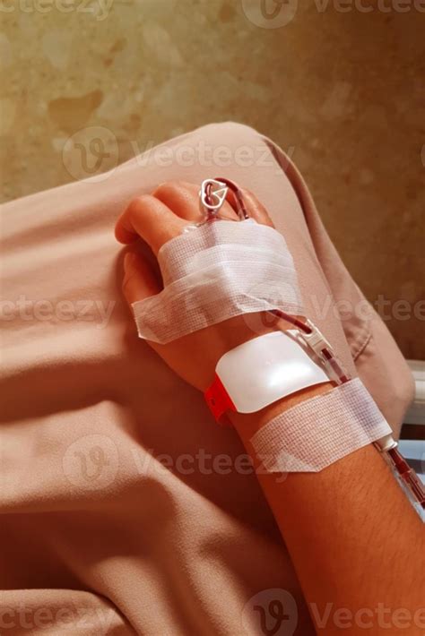 imagen borrosa de la mano de un paciente con tubo intravenoso para ...