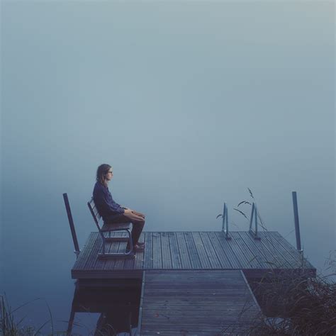 Man sitting on dock. Feeling of the photo is melancholic, narrative and ...