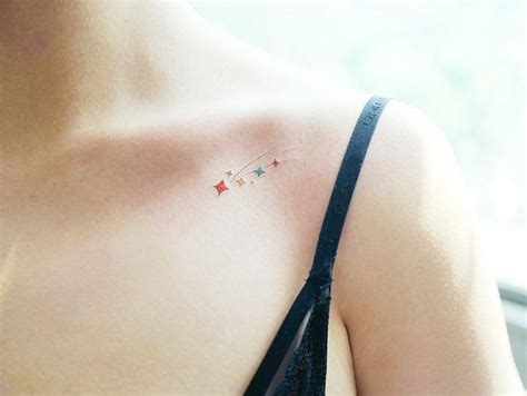 Colorful shooting star tattoo on the collarbone.