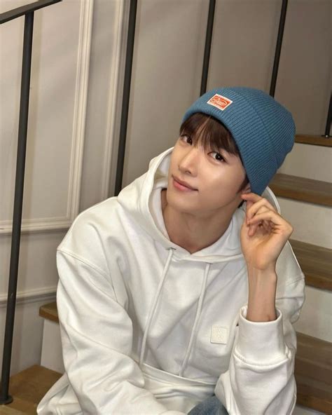 a young man wearing a blue hat sitting on stairs