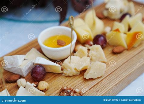 Wooden Tray with Cheese Cuts, Nuts, Grapes and Honey. Stock Image ...