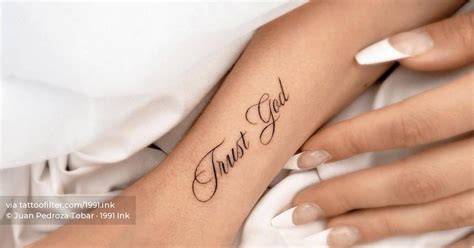 "Trust God" lettering tattoo on the wrist