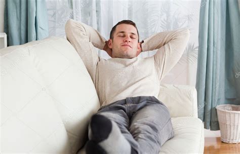 Young man resting on a sofa — Stock Photo © Wavebreakmedia #11197146