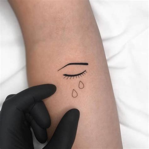 Crying eye tattoo on the inner forearm.