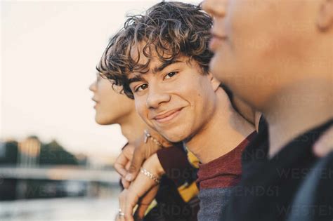 Portrait of smiling teenager with friends standing in city stock photo