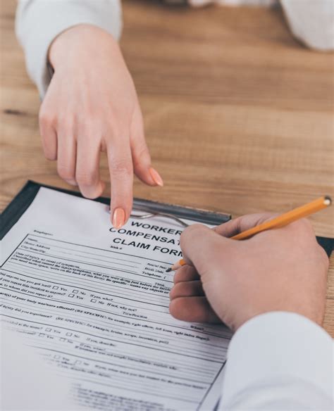 cropped view of businessman filling in compensation claim form at ...