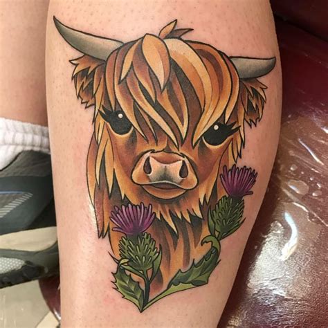 a bull with long horns and flowers on his leg is shown in this tattoo ...