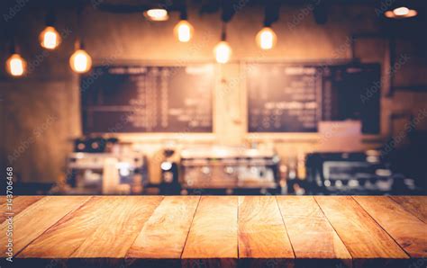 Wood table top with blur counter coffee shop,cafe background.For ...