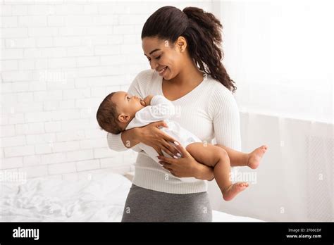 Black Mom Holding Baby In Arms Standing In Bedroom Indoor Stock Photo ...