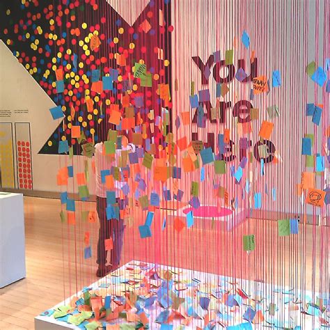 an art exhibit with many colorful objects hanging from it's walls and ...