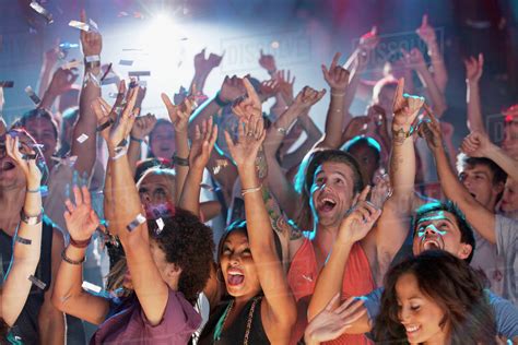 Enthusiastic crowd cheering at concert - Stock Photo - Dissolve