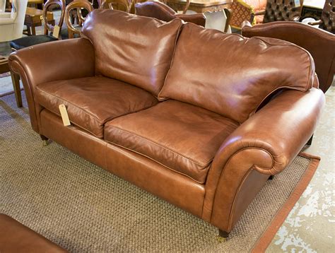 LAURA ASHLEY SOFA, with scrolling arms in a burnt sienna leather on ...