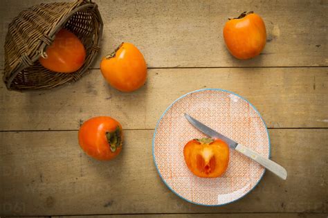 Whole and sliced kaki persimmons stock photo