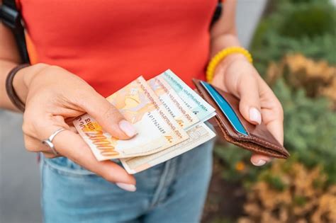 Premium Photo | The woman took out armenian dram banknotes and holds ...