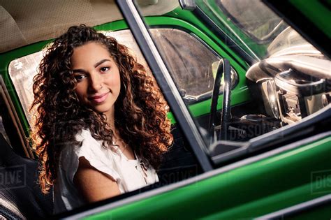 Mixed race woman driving vintage car - Stock Photo - Dissolve