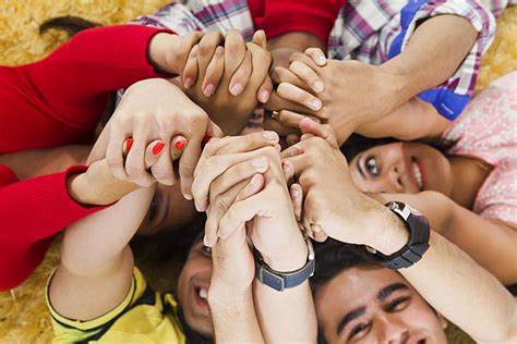 Happy Group Young Friends Lying on-Rug Holding Hands Together Support