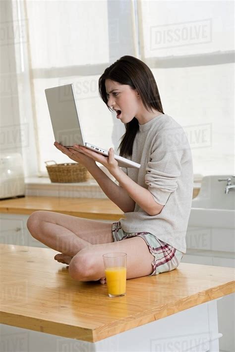 Angry woman looking at laptop - Stock Photo - Dissolve