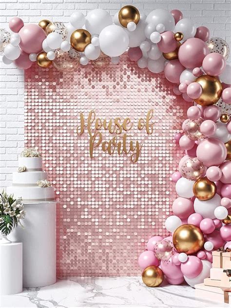 a pink and gold party backdrop with balloons