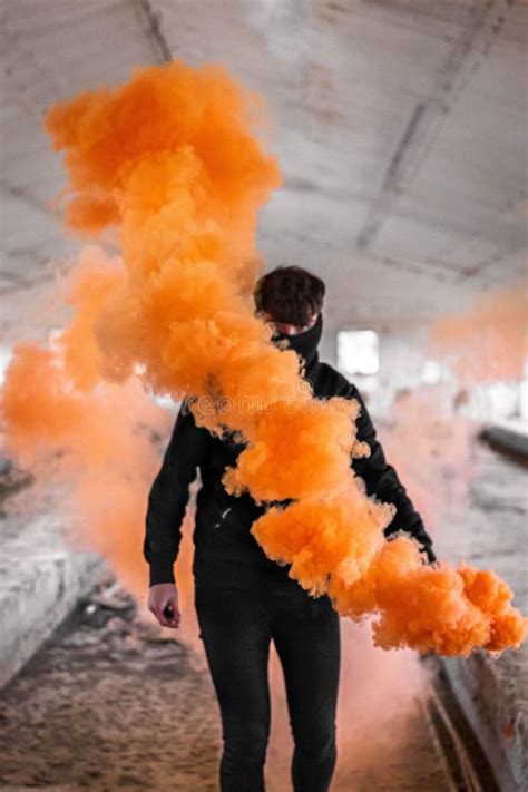 Vertical Shot of a Young Boy Carrying an Orange Smoke Bomb in an ...