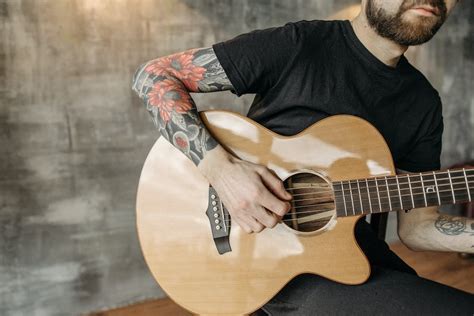 A Tattooed Man Playing Guitar · Free Stock Photo