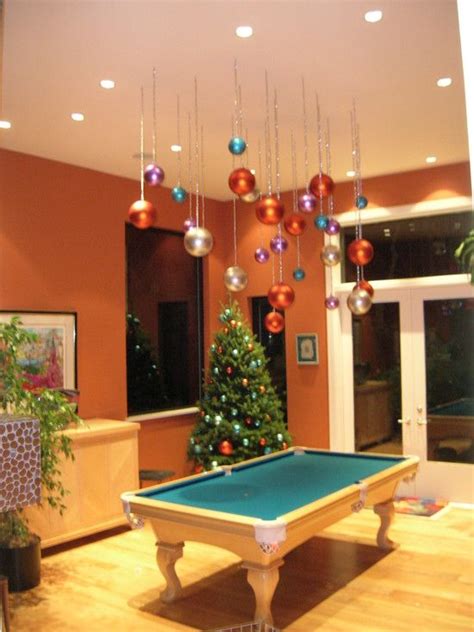 a pool table in the middle of a living room with christmas decorations ...