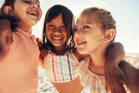 Capturing happy summer moments. Three happy little girls smiling for a ...