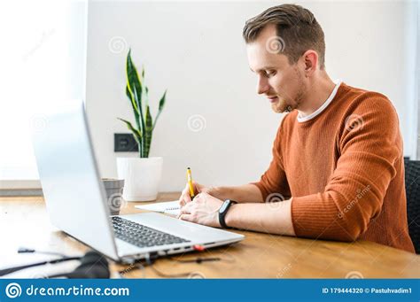 Guy Looks at Laptop and Notes in Notebook Stock Photo - Image of ...