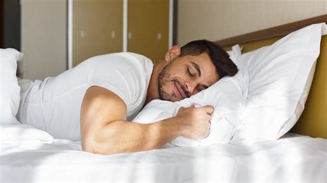 Young man peacefully sleeping in his bed – International Institute of Sleep