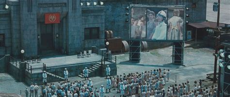 a large group of people standing in front of a giant screen on the side ...