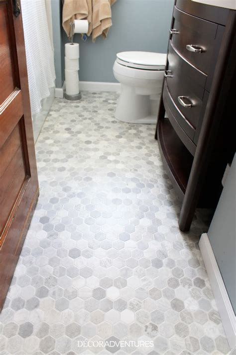 a bathroom with a toilet, sink and wooden cabinet in the corner next to it