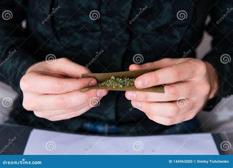 Man Preparing and Rolling Marijuana Cannabis Blunt. Close Up of Addict ...